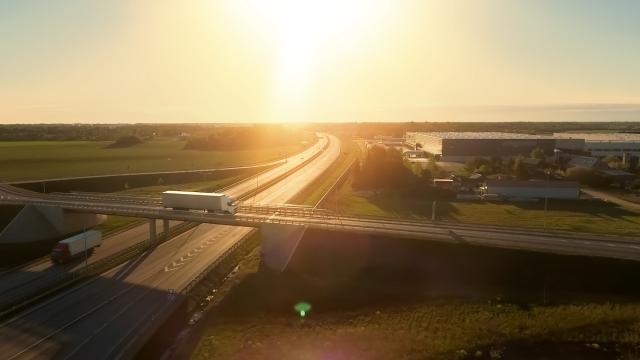 Sunrise over highway ramp while semi drives