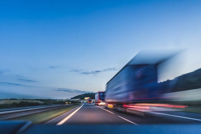 Rear of semi trucks driving at dusk