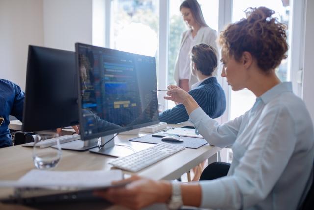 Woman pointing at a computer in an office