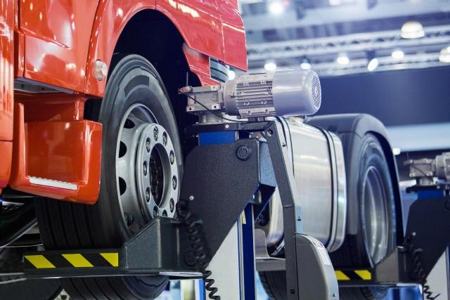 A semi truck being fixed in a mechanic bay