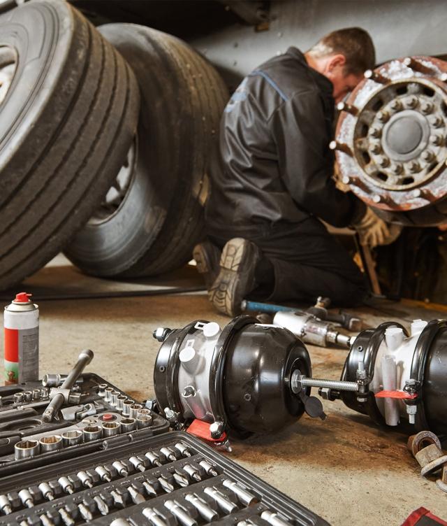 mechanic repairing tire with tools in foreground