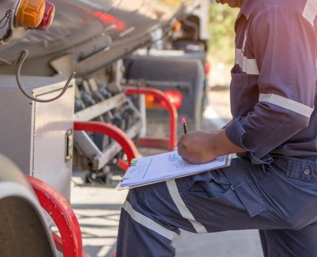 driver with paperwork outside of cab