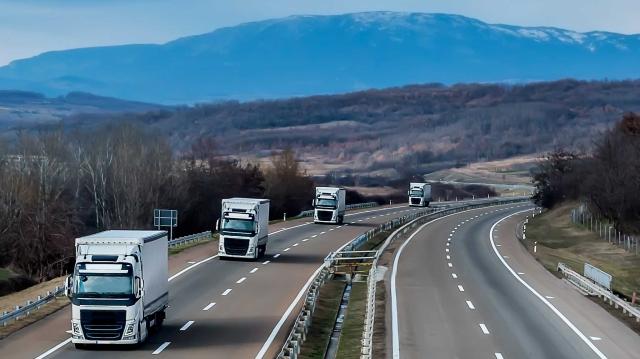 Four trucks driving on the highway