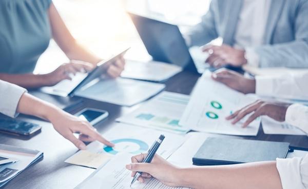 Group of people working with charts and spreadsheets